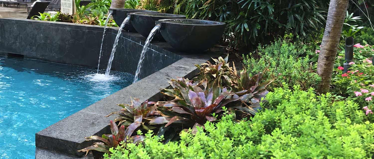 Black lava stone pool coping and water feature wall